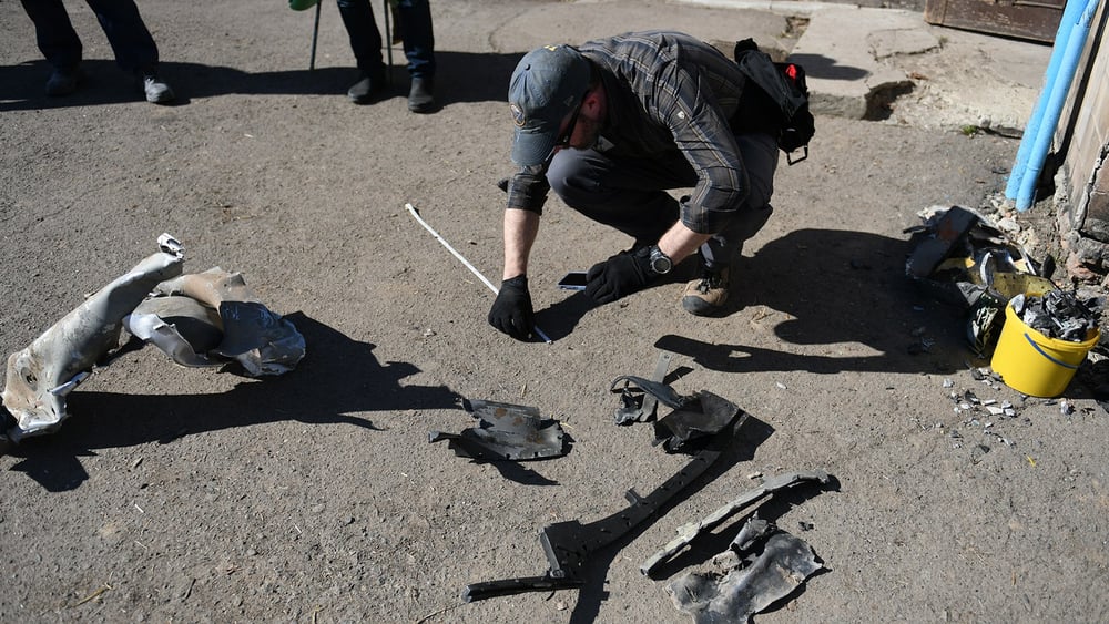 Brian Castner, enquêteur sur les armes au sein de l'équipe d'Amnesty International en train de fouiller dans les décombres des quartiers de Rivne qui ont été touchés par les frappes russes du 14 mars 2022.© Olga Ivashchenko/Amnesty International