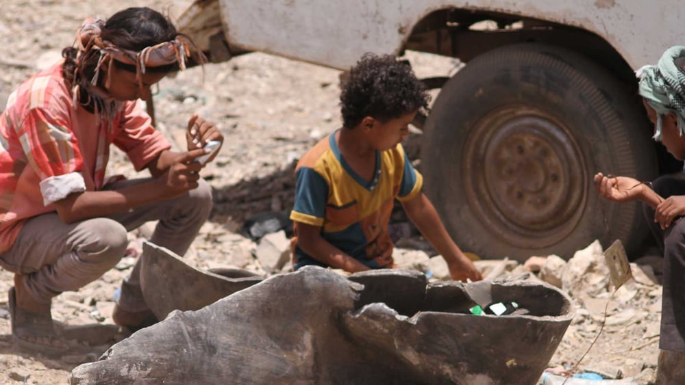 Des enfants du village d'Al-Akma jouant avec les restes d'une bombe MK80 utilisée dans une attaque aérienne.