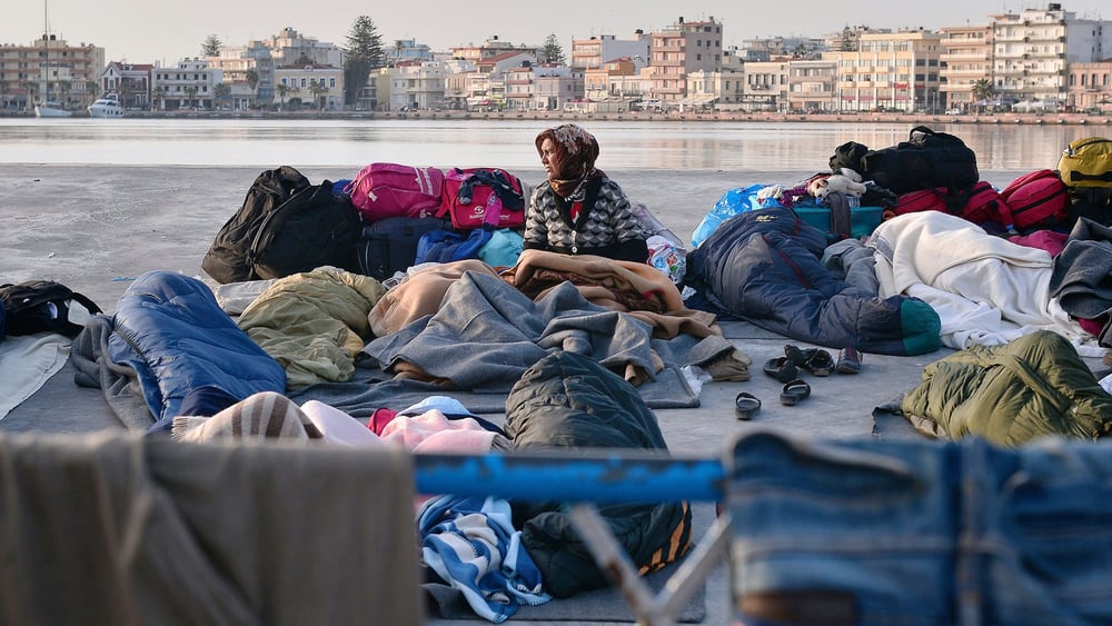 Une femme réfugiée se réveille dans le port de Chios, où les réfugié·e·s et les migrant·e·s passent leur nuit à l'air libre. 5 avril 2016.