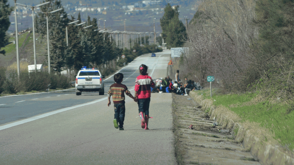 Deux enfants marchent au bord de la frontière avec la Macédoine, Idomeni, Grèce, février 2016. © Amnesty International
