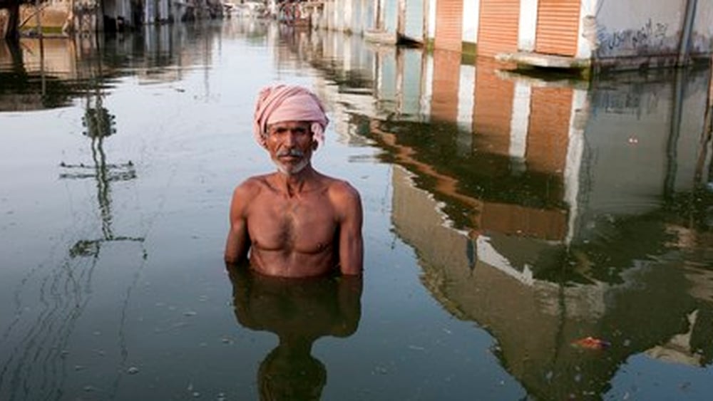 Ein indischer Mann mit Turban, der brusttief im Wasser steht.