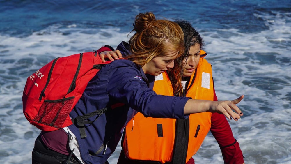 Les personnes qui aident les réfugiés et les migrants risquent d'être dénoncés et punis. Cette aide soutient un jeune migrant qui vient d'arriver à Lesbos. © Aleksandr Lutcenko / shutterstock.com