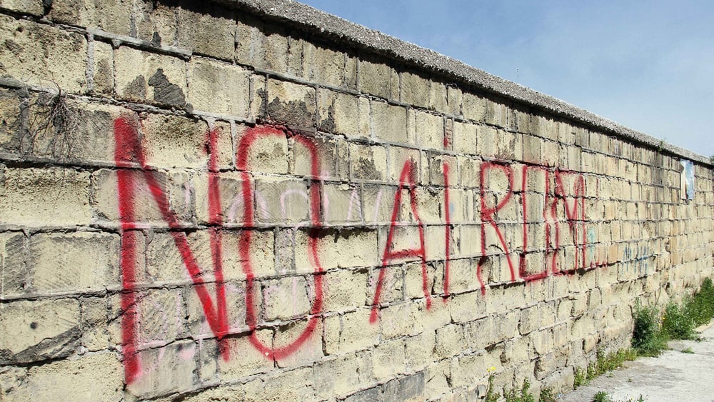 Un mur sur lequel est écrit en rouge « No ai Roma » (en italien, « Non aux Roms »)