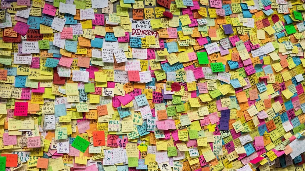 Un muro vicino agli edifici governativi centrali di Hong Kong nell'ottobre 2014, ricoperto di post-it a sostegno del movimento democratico. Gli attivisti pro-democrazia sono stati e continuano ad essere perseguitati dal governo cinese. © AFP via Getty Images
