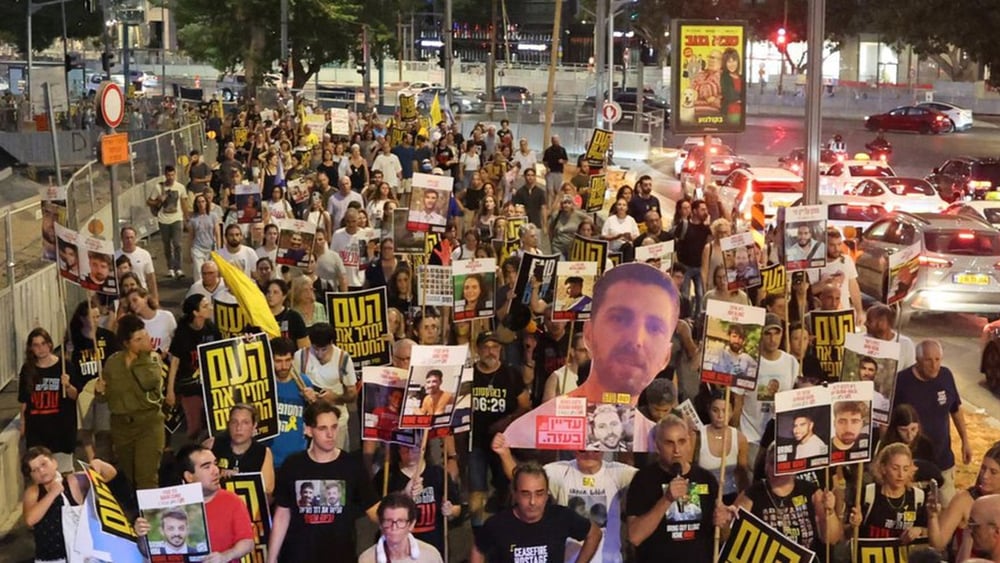 I familiari degli ostaggi israeliani e i loro sostenitori mostrano foto e cartelli durante una manifestazione per chiedere l'intervento delle autorità al fine di ottenere il rilascio degli ostaggi detenuti a Gaza dal 7 ottobre 2023, davanti alla sede del Ministero della Difesa israeliano a Tel Aviv, in Israele, il 6 agosto 2025. © Jack Guez/AFP via Getty Images