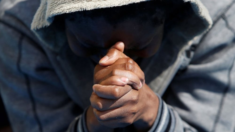 Un uomo prega dopo esser stato soccorso dalla nave Topaz dell’organizzazione di aiuto private MOAS (Migrant Offshore Aid Station) a 20 miglia nautiche dalla costa libica, 23 giugno 2016. © REUTERS/Darrin Zammit Lupi
