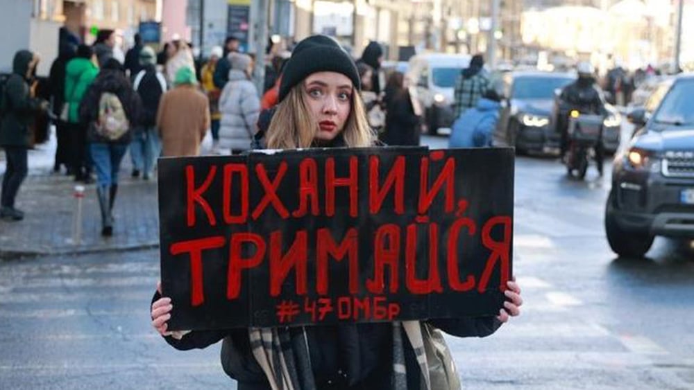 Alina Potapova mostra un cartello durante una manifestazione a Kyiv : « Resisti, amore mio ». Il suo fidanzato è sparito nel luglio 2023. È stato confermato che è detenuto in segreto in Russia. © Oleksandr Khomenko/Amnesty International