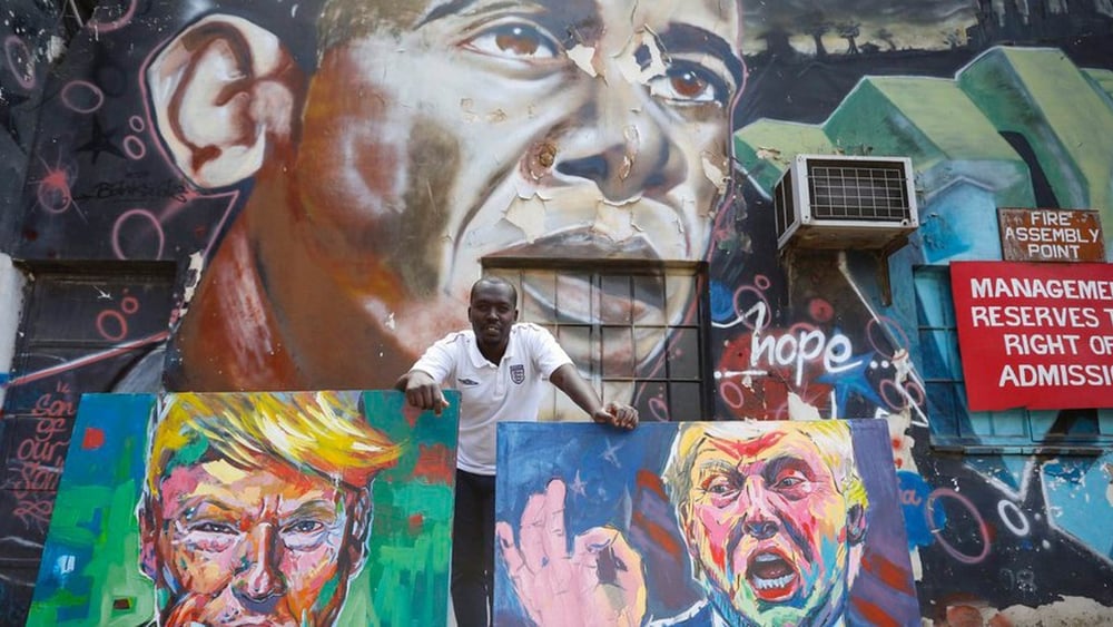 L’artista kenyota 'Yegonizer' posa con i suoi ritratti di Trump davanti a un murales dedicato a Obama dell’artista Bankslave. © Keystone/EPA/DAI KUROKAWA