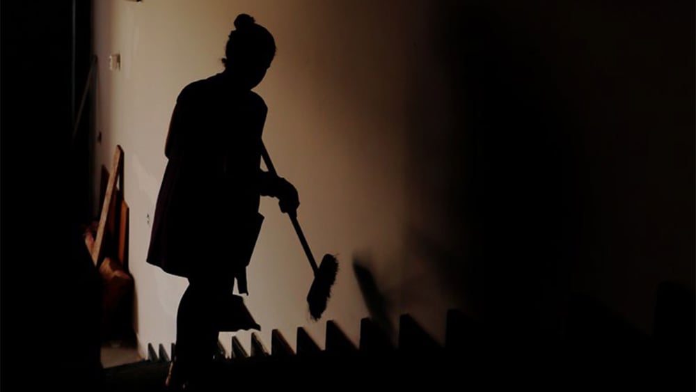L'ombra di una donna che passa la scopa sulle scale