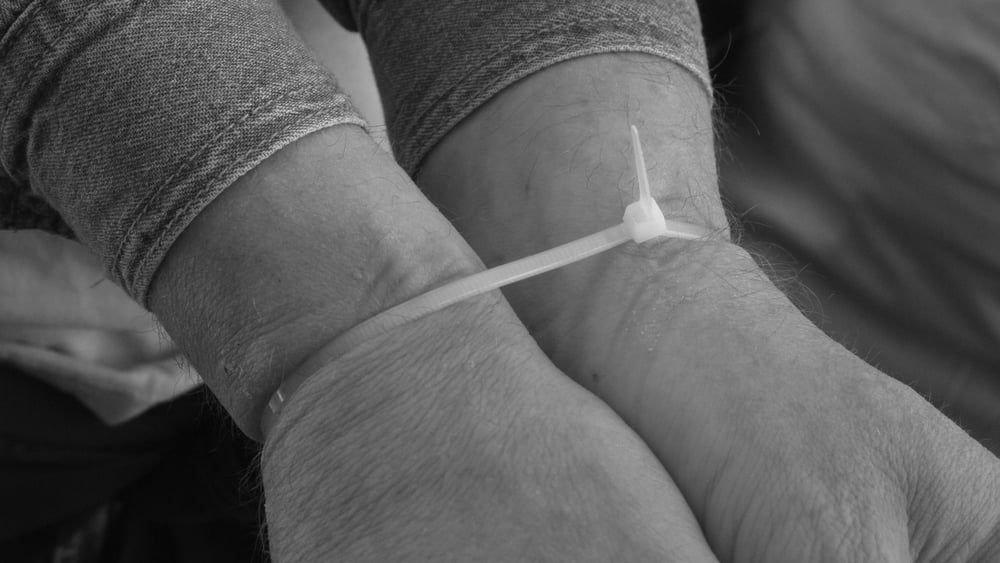 Due mani legate con una fascetta serracavi.