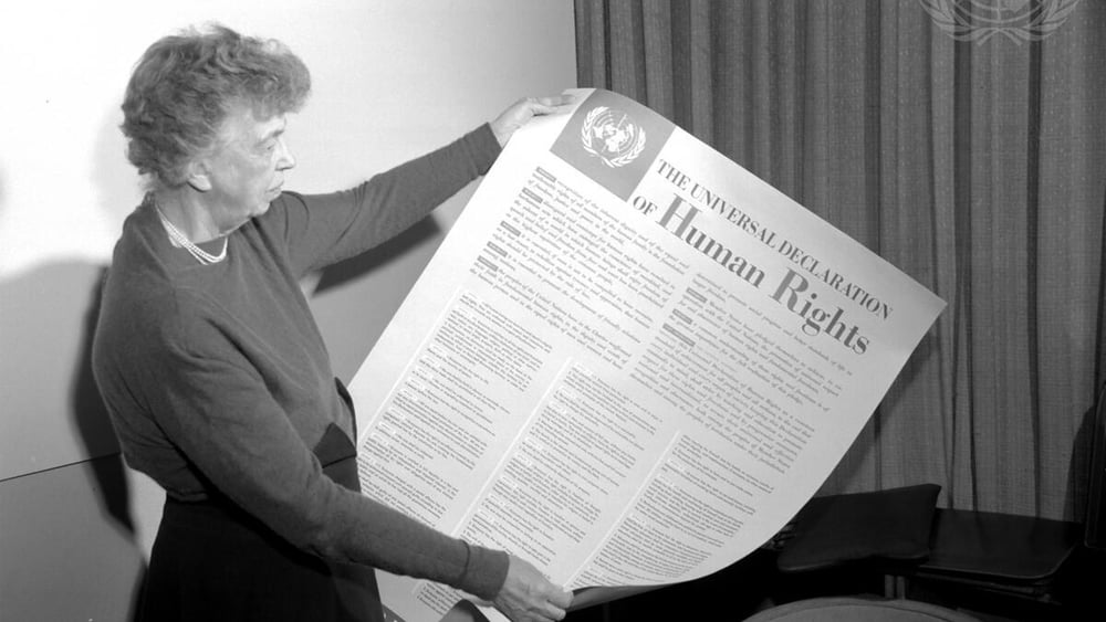 Eleanor Roosevelt, che nel 1947 presiedeva la Commissione per i diritti umani delle Nazioni Unite, con un grande manifesto della Dichiarazione Universale dei Diritti dell'Uomo (titolo originale).