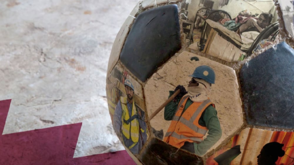 Dettaglio di un pallone da calcio, con stampate sopra fotografie di lavoratori migranti impegnati nei cantieri del Mondiale Qatar 2022.