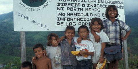 Kinder der Gemeinde San José de Apartado stehen vor einem Schild das auf die neutrale Zone hinweist. | © privat