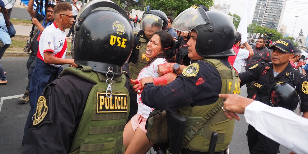 Eine Frau wird verhaftet, weil sie rote Farbe gegen die Polizei geworfen hat an einer Demonstration in Lima vom 3. Januar 2023 © IMAGO / ZUMA Wire / Carlos Garcia Granthon