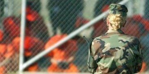 US-Soldatin bewacht Gefangene in Guantánamo, die kniend der Bruthitze ausgesetzt sind  © US DoD