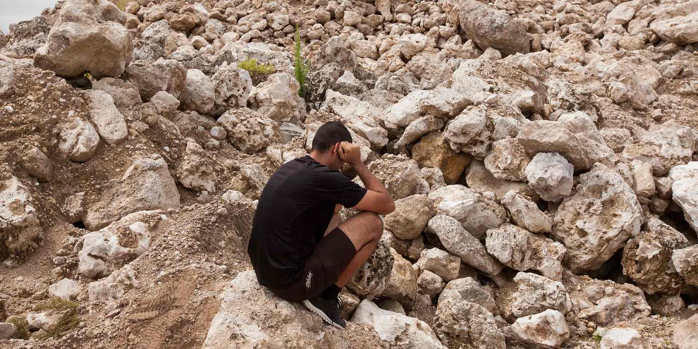 Ein iranischer Flüchtling sitzt in einer verlassenen Phosphatmine auf der Insel Nauru. © Rémi Chauvin
