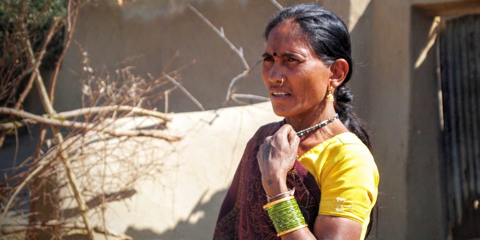 Die Adivasi-Frau Nirupabai neben ihrem Haus, das neun Tage zuvor zerstört worden war, um der Erweiterung der Kusmunda Mine Platz zu machen. All ihr Besitz und die Getreideernte eines Jahres wurden dabei vernichtet. Januar, 2014. © Amnesty International India