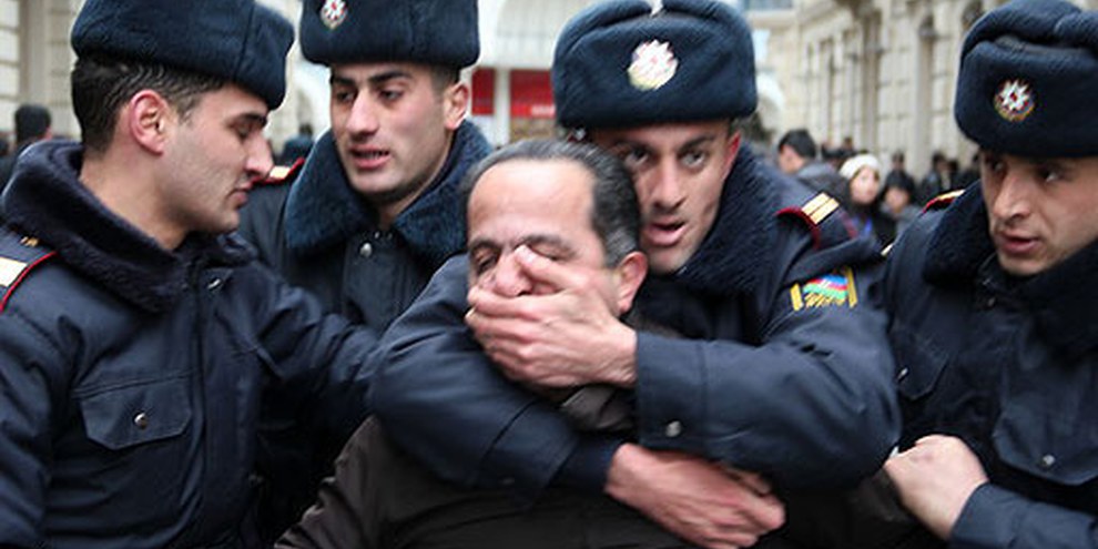 Polizisten bringen einen Aktivisten zum Verstummen. Baku, 12. März 2011. © AI