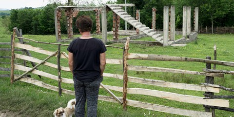 Eine Überlebende in Osten von Bosnien betrachtet ihr zerstörtes Haus. Staatliche Unterstützung und Hilfsprogramme kommen oft kaum bis in die ländlichen Gebiete © ZIYAHGAFIC