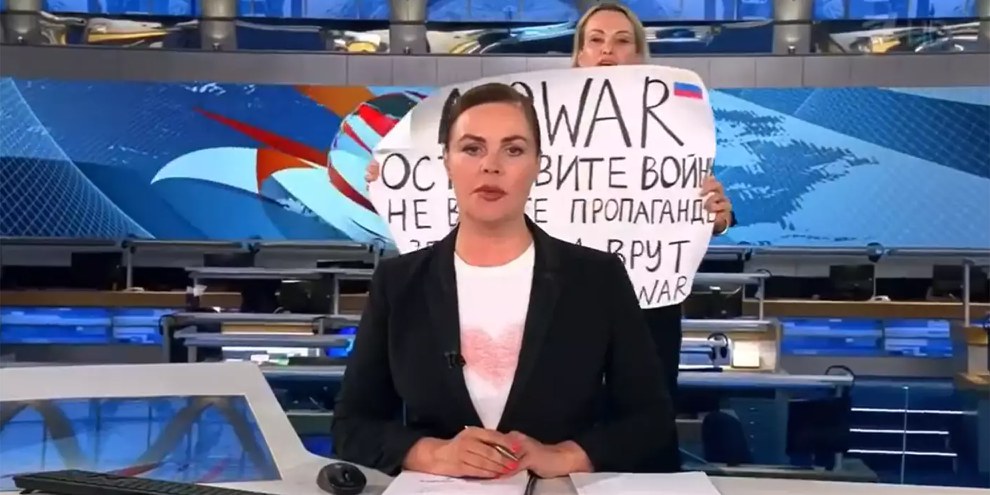 Am 14. März tauchte Marina Ovsiannikova hinter der Nachrichtensprecherin mit einem Plakat gegen den von Russland geführten Krieg auf. © Screenshot