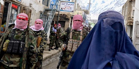 Die Menschenrechte von Frauen in Afghanistan werden massiv verletzt und es gibt kaum Schutz vor geschlechtsspezifischer Gewalt. Bild: Sicherheitskräfte der Taliban bewachen eine burkabekleidete afghanische Frau auf einem Markt im Bezirk Baharak der Provinz Badachschan. © AFP/Getty