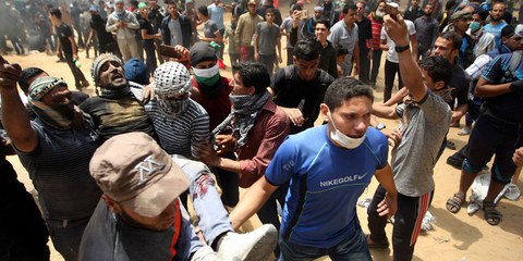 Palästinenser tragen im Gazastreifen einen verletzten Demonstranten weg. 14. Mai 2018. © Keystone/Newscom/Ismael Mohamad