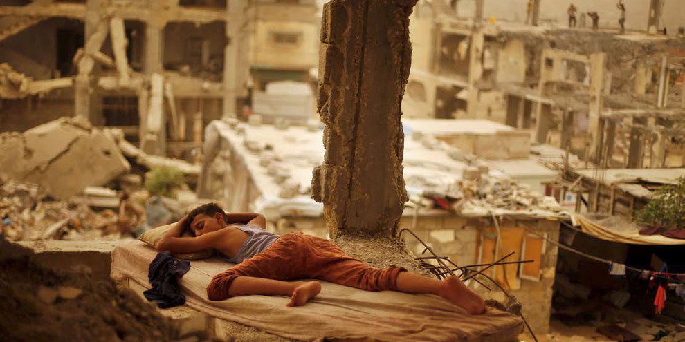 Knabe während eines Sandsturms in Gaza, September 2015. Immer noch sind viele Gebäude zerstört. © Suhaib Salem/Reuters