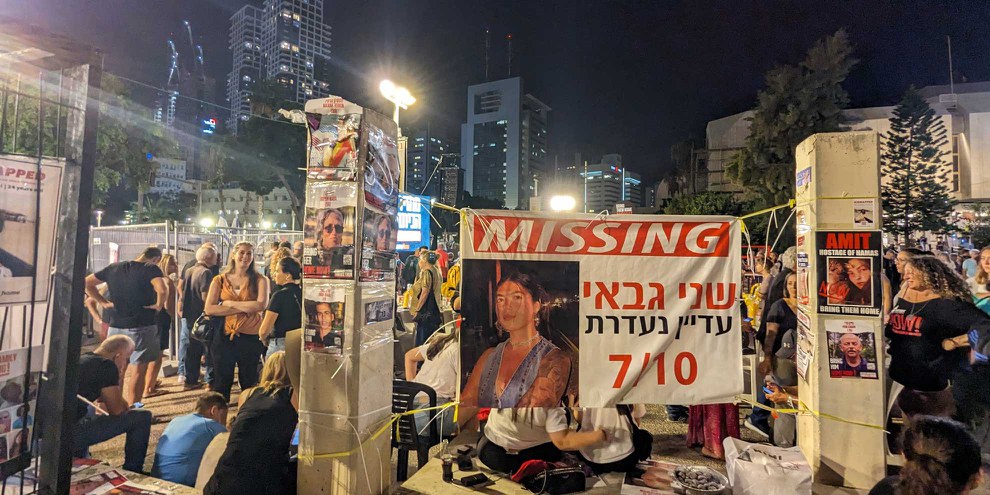 Schilder von  Geiseln und Vermissten an einer Demonstration in Tel Aviv. Das grosse Schild in der Mitte zeigt Shani Gabai, die zu diesem Zeitpunkt noch als vermisst galt. Am 22. November, elf Tage nach der Aufnahme dieses Bildes, wurde bekannt gegeben, dass sie als eine der beim Nova Music Festival getöteten Personen identifiziert wurde. © Gil Naveh/ Amnesty International Israel