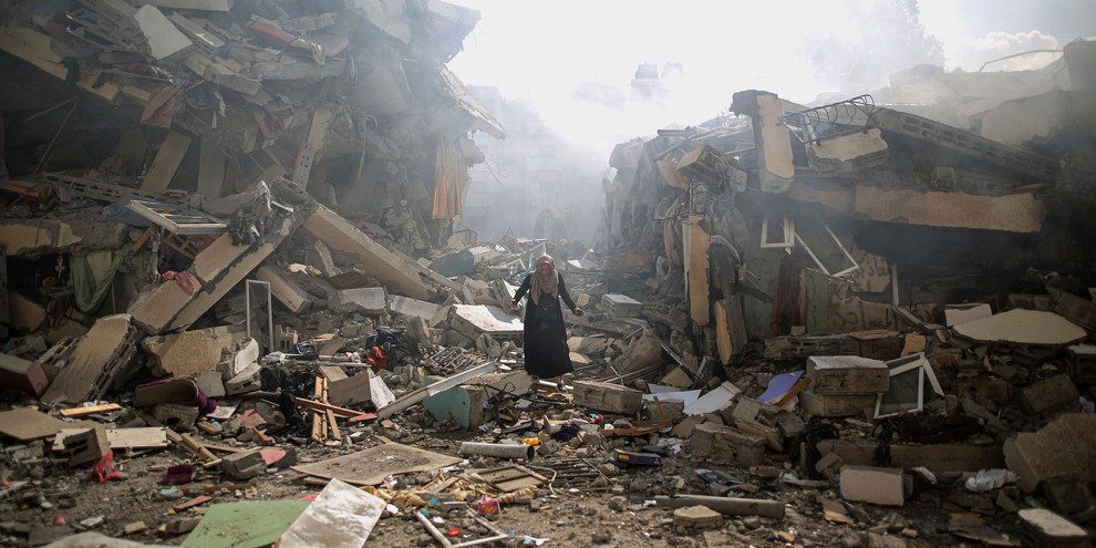 Eine Palästinenserin zwischen Trümmern von Wohngebäuden im Stadtteil al-Zahra im Gazastreifen nach israelischen Luftangriffen am 19. Oktober 2023 . ©  Mustafa Hassona/Anadolu via Getty Images   Weitere Bilder sehen Sie beim Klick auf dieses Bild.