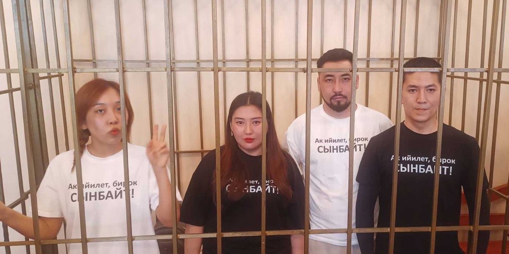 Die vier Journalist*innen des kirgisischen Medienprojekts Temirov LIVE – Aike Beishekeeva, Makhabat Tazhibek-kyzy, Azamat Ishenbekov und Aktilek Kaparov – während ihrer Gerichtsverhandlung / Die Aufschrift auf den T-Shirts: «Die Wahrheit verbiegt sich, sie bricht aber nicht» (auf Kirgisisch) © Privat