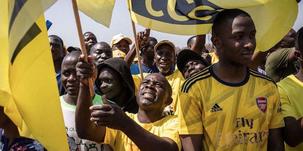 Anhänger des Oppositionsführers der Citizens Coalition for Change (CCC), Nelson Chamisa, schwenken die Flagge ihrer Partei während ihrer letzten Wahlkampfkundgebung in Harare am 21. August 2023 © AFP via Getty Images
