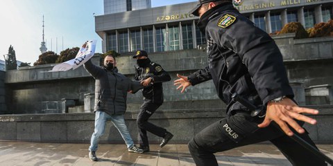 Der Direktor der Online-Publikation «Abzas Media» Ulvi Hasanli ist zu sehen, als die Polizei bei einer Kundgebung von Journalist*innen ein Plakat mit der Aufschrift «Journalismus ist kein Verbrechen» beschlagnahmt. (Baku/Aserbaidschan 28.12.2024) © Aziz Karimov/Getty Images