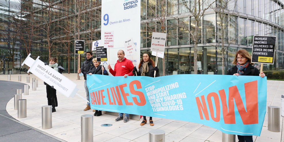 Alliance Sud, Public Eye und Amnesty Schweiz demonstrierten am 30. November 2021 gemeinsam vor dem Hauptsitz der IFPMA (International Federation of Pharmaceutical Manufacturers & Associations), in Genf für einen Verzicht auf das Patent für Covid-19-Impfstoffe.