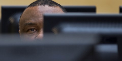 Den Haag, 27. November 2013: Der ehemalige kongolesische Präsident Jean-Pierre Bemba verbirgt zu Beginn seines Prozesses am ICC sein Gesicht vor den Reportern und Prozessbeobachterinnen. © Peter Dejong / AP Pool