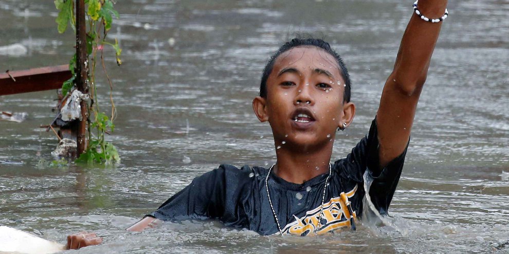 © Ein Junge auf der philippinischen Insel Luzon watet nach einem Sturm im Wasser. September 2017. © Reuters / Erik De Castro