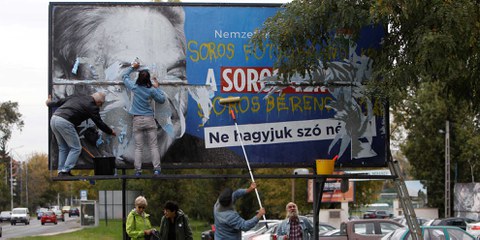 Aktivisten entfernen ein Plakat, auf dem George Soros beschuldigt wird, eine Million MigrantInnen pro Jahr in Europa ansiedeln zu wollen. © REUTERS/Bernadett Szabo