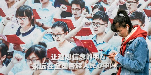 Zwischen moderner Medienwelt und klassischer Propaganda: Eine junge Chinesin vor einem Werbeplakat im Vorfeld des Volkskongresses 2019. © KEYSTONE/EP/Roman Pilipey