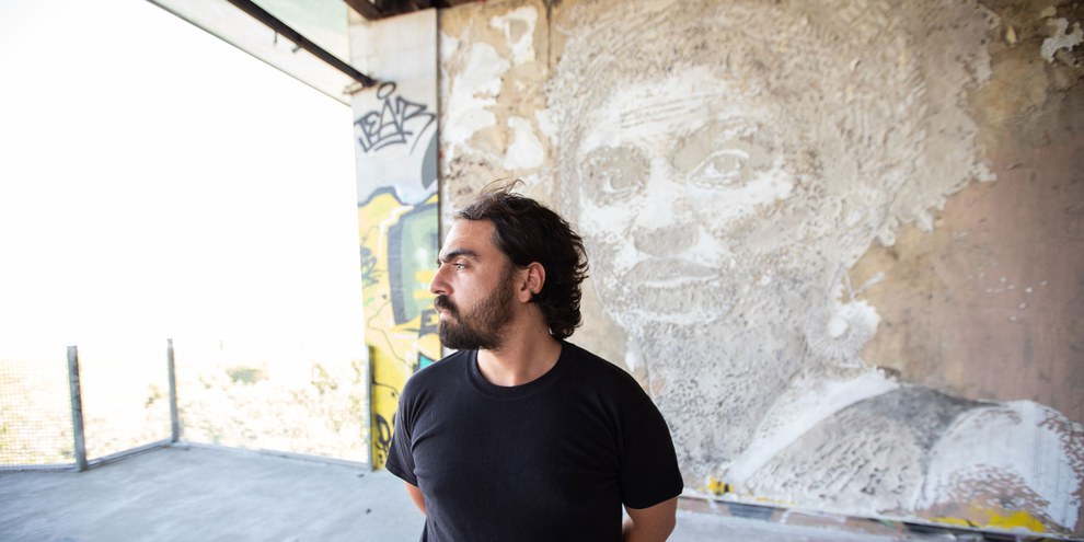 Künstler Vhils vor seinem Wandgemälde zu Ehren von Marielle Franco in Lissabon, Portugal. © Fernando Figueiredo Silva