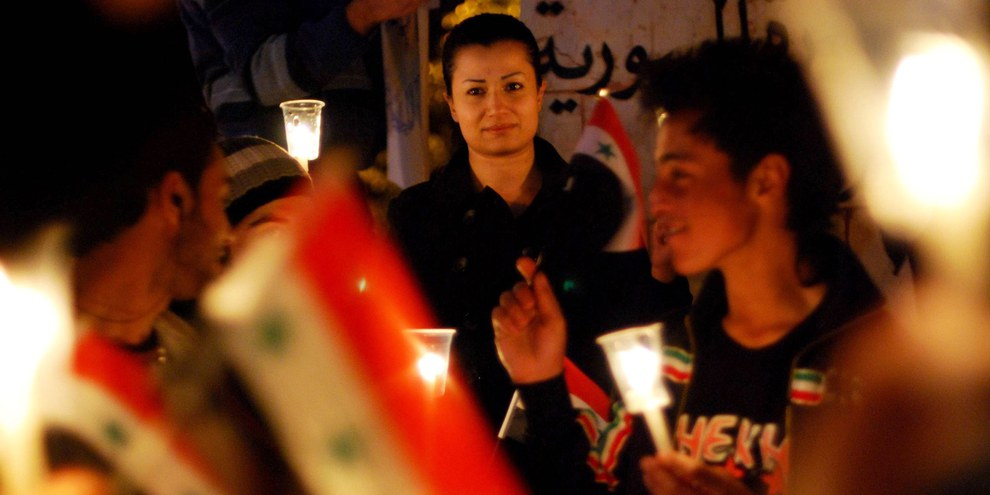 Demonstrant*innen protestierten am 28. März 2011 in Swaeda im Süden Syriens mit Flaggen und Kerzen gegen die brutale Gewalt der Regierung. © IMAGO / UPI Photo