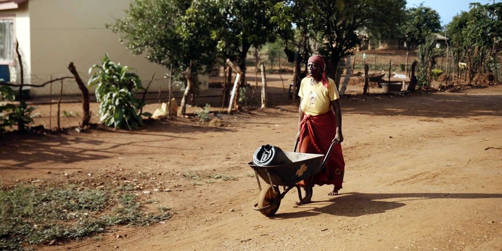Sarah Makhubela ist mit ihrer Schubkarre auf dem Weg zum Wassertank. © Jasmin Sarwoko