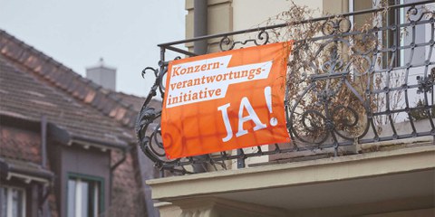 Jetzt sollten sie unbedingt wieder raus, an die Fenster und ie Balkone: Die Fahnen der KVI © konzernverantwortung.ch