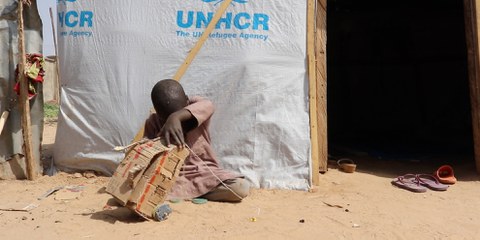 Un petit garçon joue devant son abri dans un camp de personnes déplacées à l'extérieur de Maiduguri, dans l'État de Borno, au Nigeria, en janvier 2020. Plus de deux millions de personnes sont déplacées à l'intérieur du pays en raison du conflit de longue date entre l'armée nigériane et Boko Haram. © AI