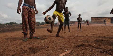 Des enfants jouent au football au bord de l'eau de Timber, près du front de mer de Bundu, à Port Harcourt, au Nigeria, en avril 2011.  © George Osodi / Amnesty International