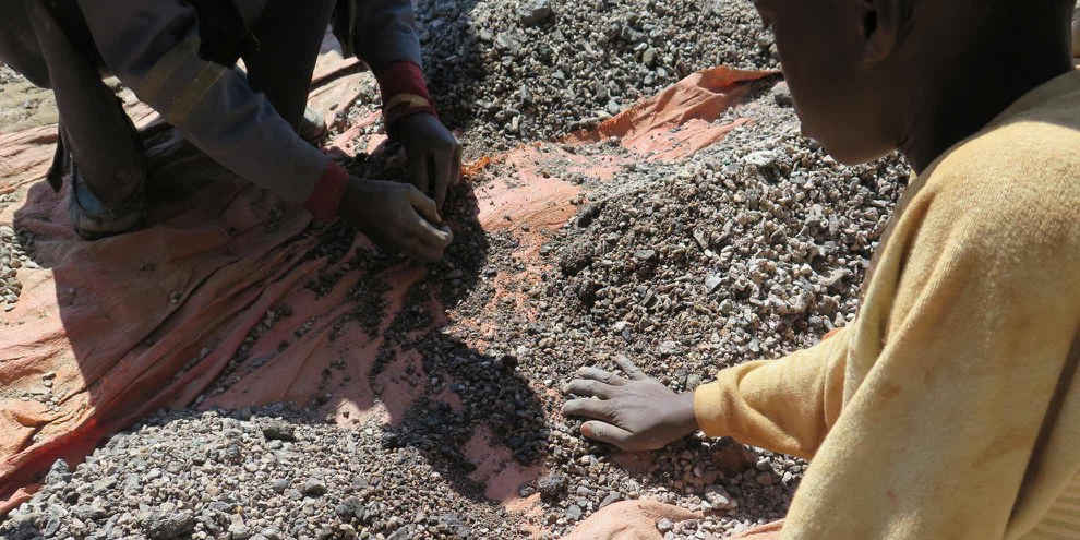 Charles, 13 ans, trie des pierres contenant du cobalt sur la rive du lac Malo Kapata en RDC. © Amnesty International.