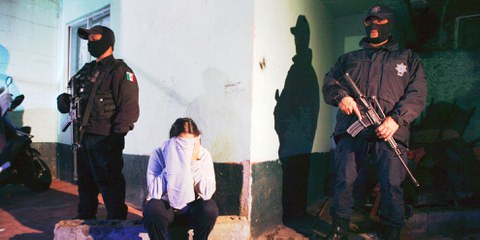 Des policiers arrêtant une femme à Mexico City, soupçonnée de trafic de drogue.  © Reuters