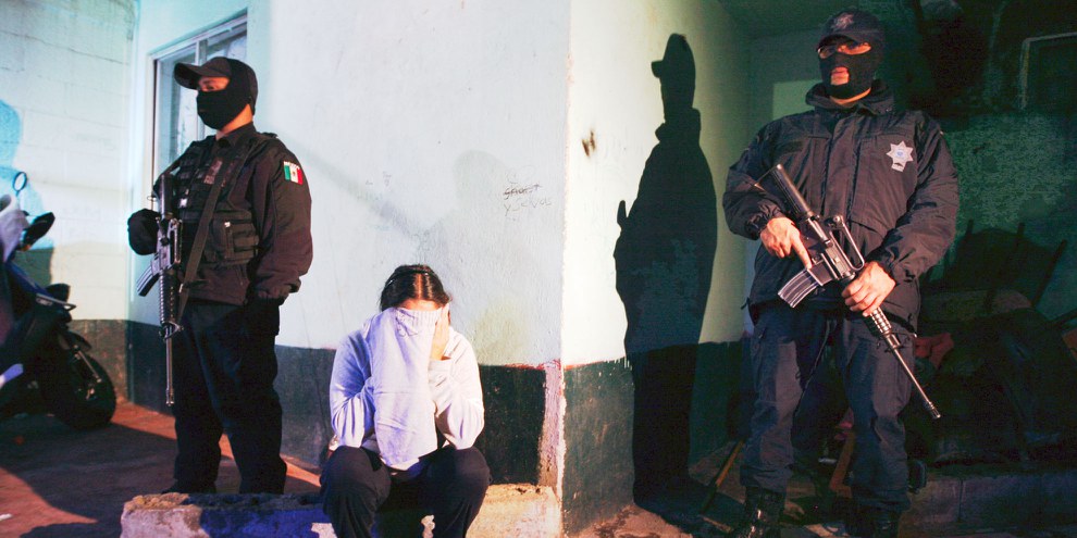 Des policiers arrêtant une femme à Mexico City, soupçonnée de trafic de drogue.  © Reuters