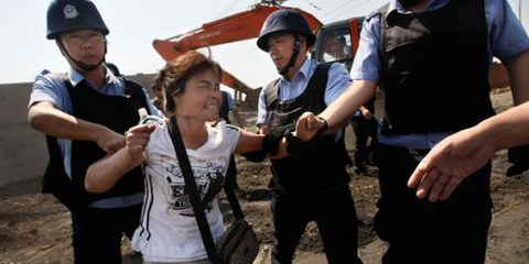 Des gens obligés de quitter leur foyer sont brutalisés par la police. © Fang Xinwu / Color China Photo / AP Photo