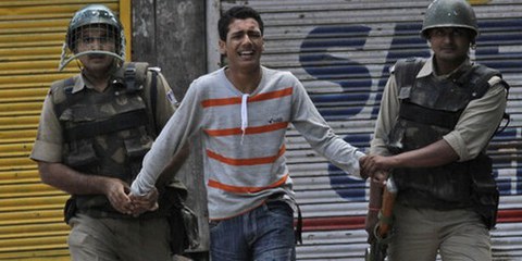 Arrestation d'un mineur par des paramilitaires indiens au Cachemire, lors d'une manifestation à Srinagar le 30 mai 2010. © AP Photo/Mukhtar Khan.