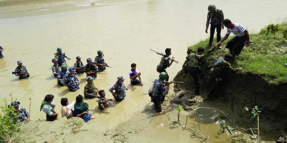 Les forces de sécurité du Myanmar accompagnent les villageois hindous jusqu'aux fosses communes où leurs proches ont été enterrés. Les corps de 45 personnes de Ah Nauk Nauk Kha Maung Maung Seik (canton de Maungdaw, État de Rakhine) ont été déterrés dans quatre fosses communes à la fin septembre 2017. Les victimes font partie des 100 personnes tuées lors de deux massacres perpétrés par l'Armée du Salut des Rohingya de l'Arakan (ARSA) le 25 août 2017. © DR