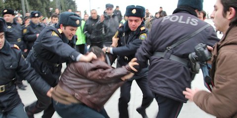Quatre policiers traînent un activiste durant les protestations de mars 2011. © AI